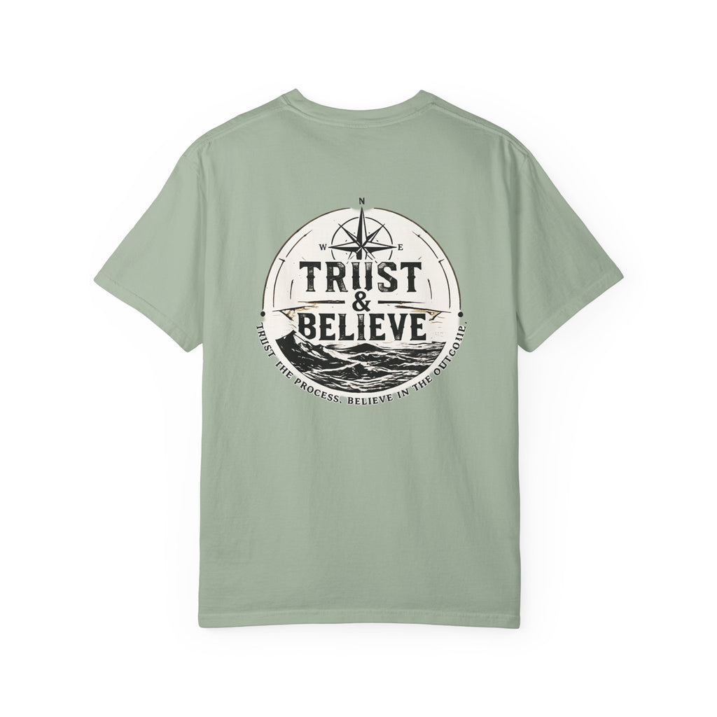 Sage green t-shirt with 'Trust & Believe' graphic on a white background