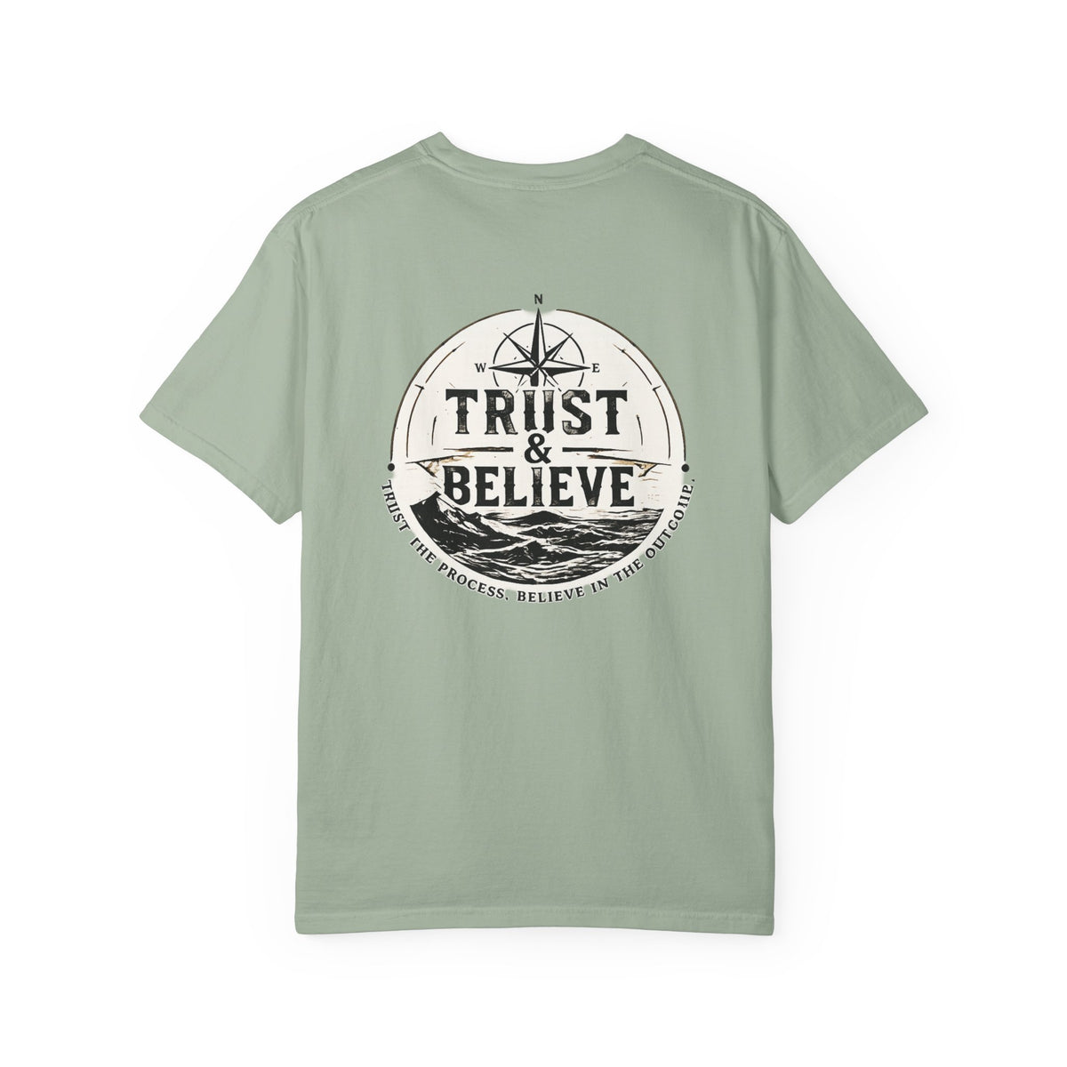 Sage green t-shirt with 'Trust & Believe' graphic on a white background